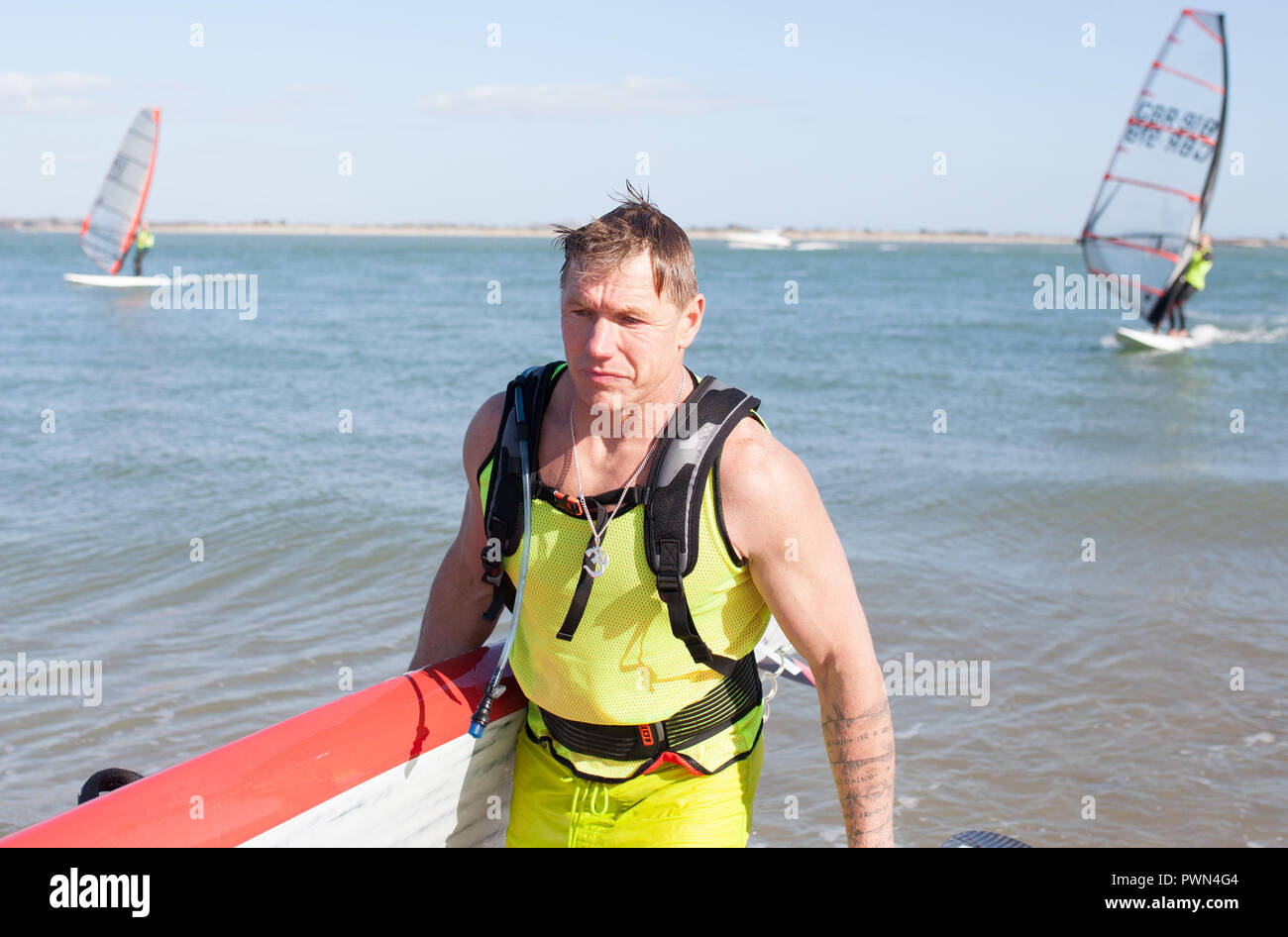 Man carrying paddle board to finish line Stock Photo