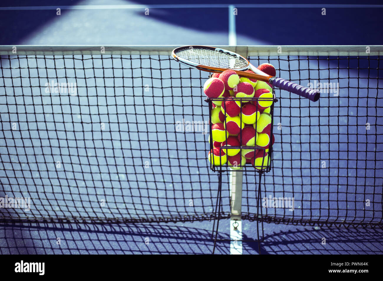 Tennis court with tennis balls in tennis ball basket stand Stock Photo