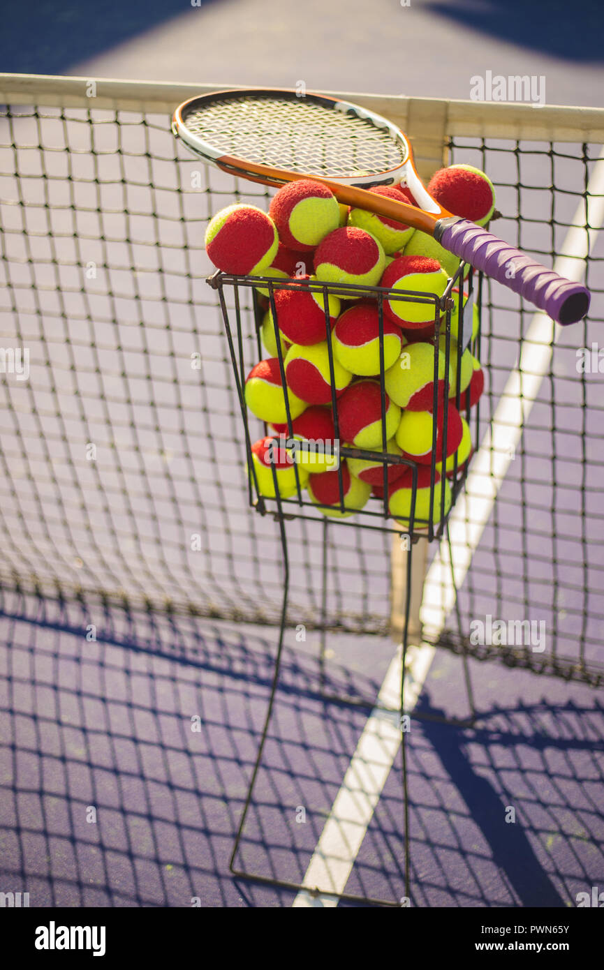 Tennis court with tennis balls in tennis ball basket stand Stock Photo