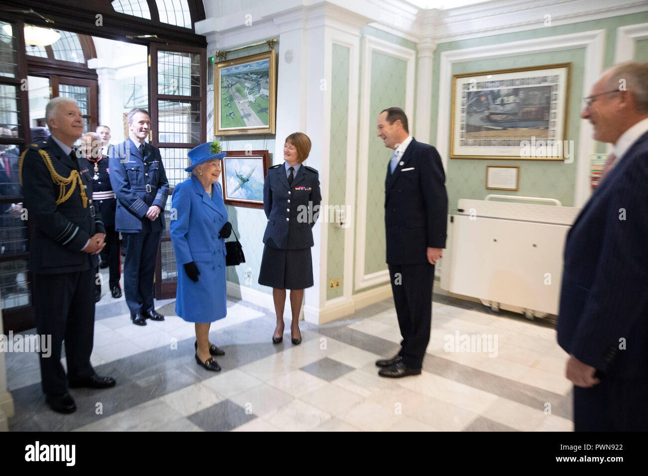 Queen Elizabeth II walks through the RAF Club with Air Marshall Sir