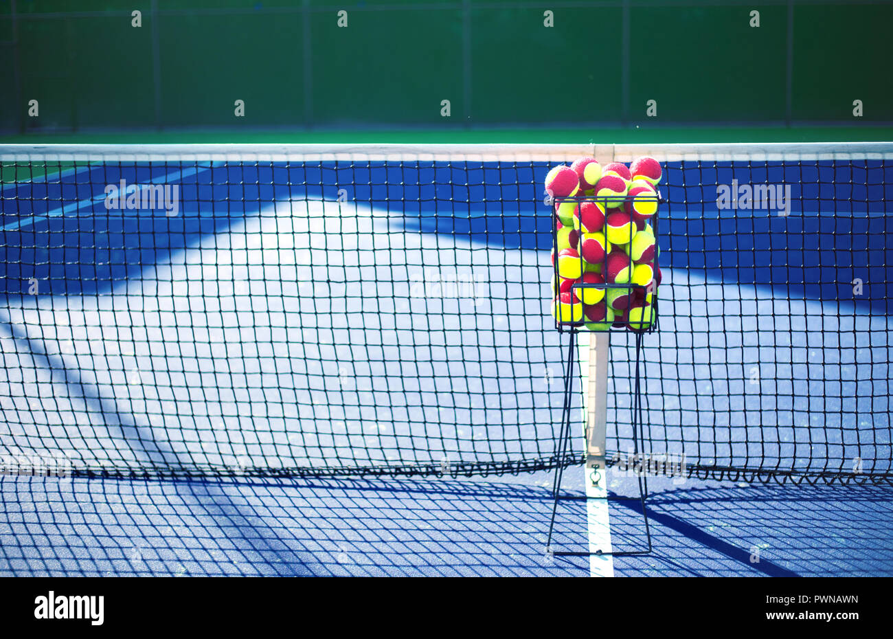 Tennis court with tennis balls in tennis ball basket stand Stock Photo