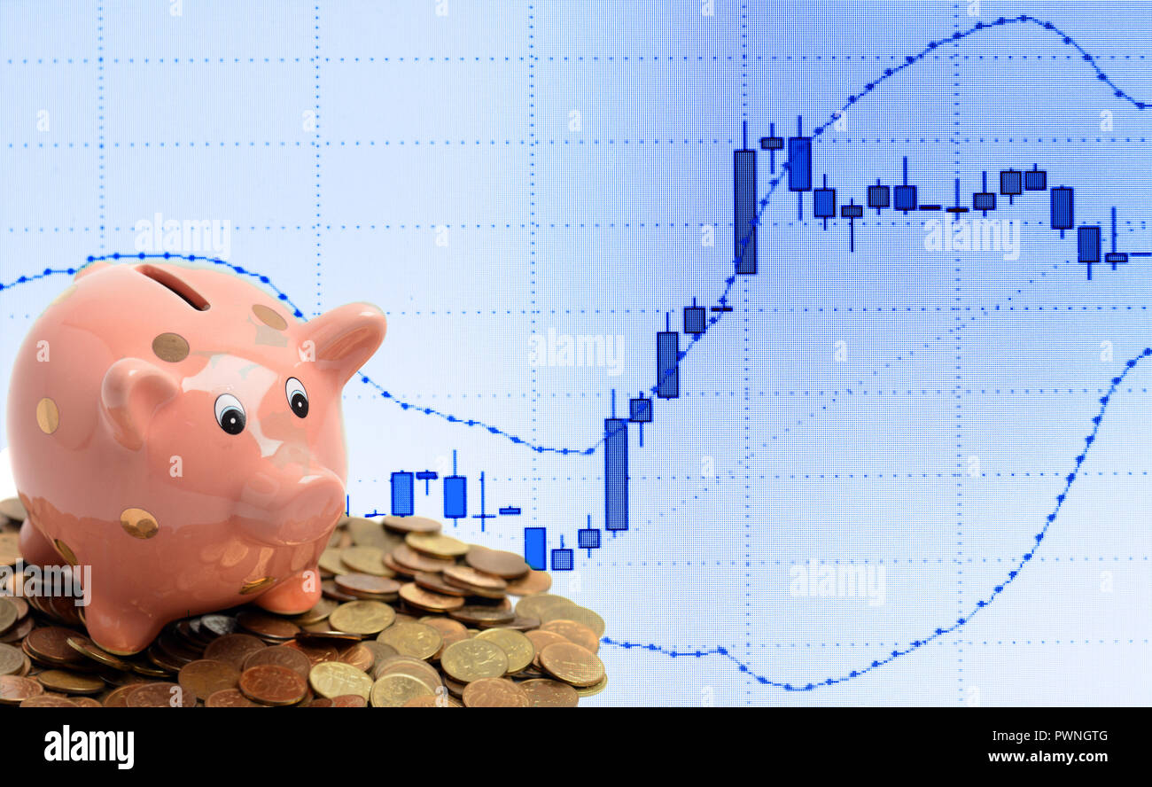 Coin piggy bank and business candle graph chart of stock market investment trading on computer screen Stock Photo