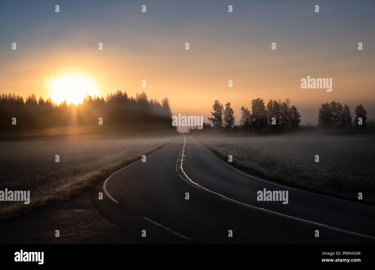 Scenic road landscape with sunrise and fog at autumn morning in Finland Stock Photo