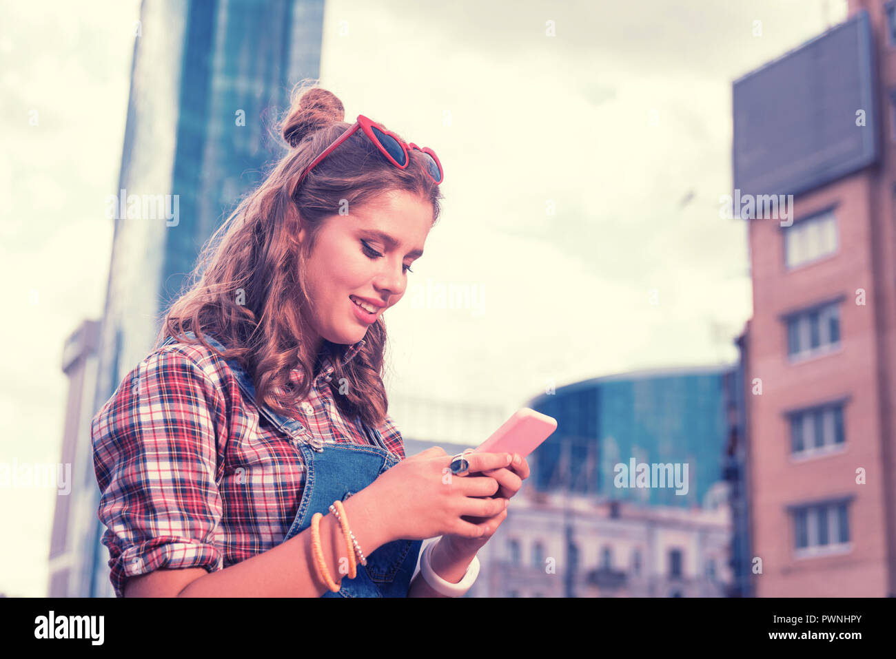 Dark-haired girl wearing beautiful ring on index finger typing message Stock Photo