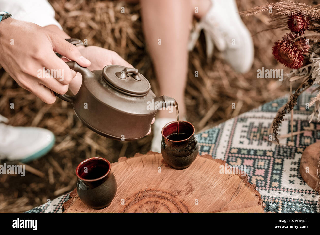 Close up of male hands that pouring tea into cup Stock Photo