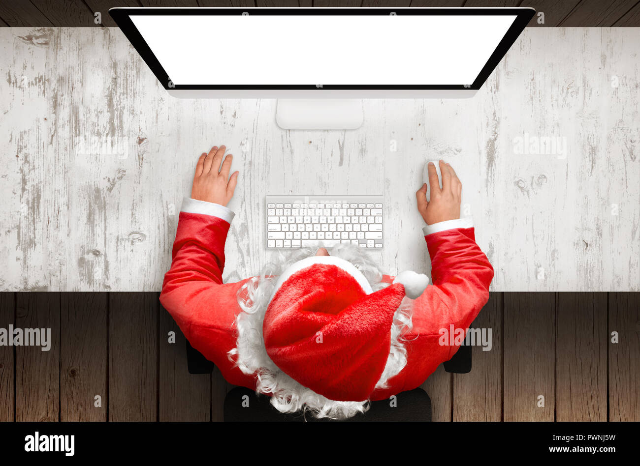 Santa claus work on desk computer with isolated display for mockup. Top ...