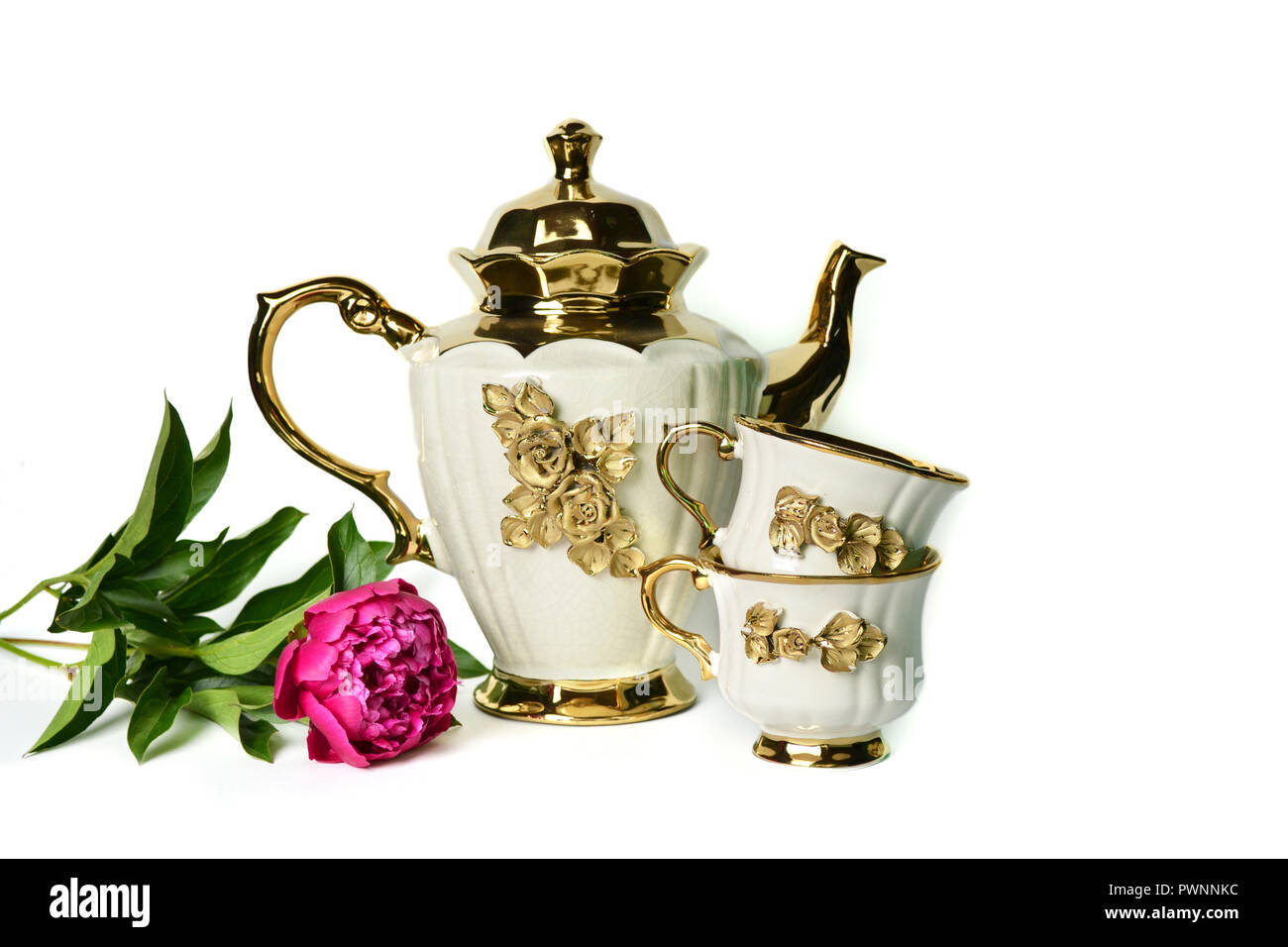 A White Teapot With A Golden Flower A Cup Of Tea And A Beautiful Lilac Peony Stock Photo Alamy