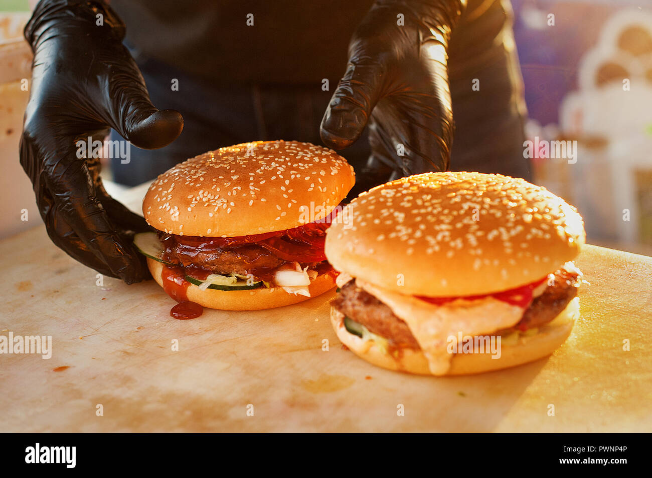 Two finished burger on a wooden board. Open kitchen in the street. Street fast food Stock Photo