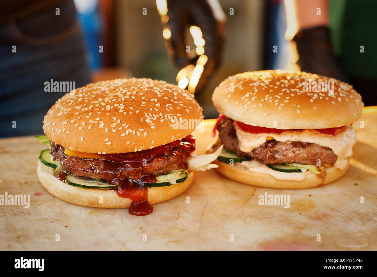 Two finished burger on a wooden board. Open kitchen in the street. Street fast food Stock Photo