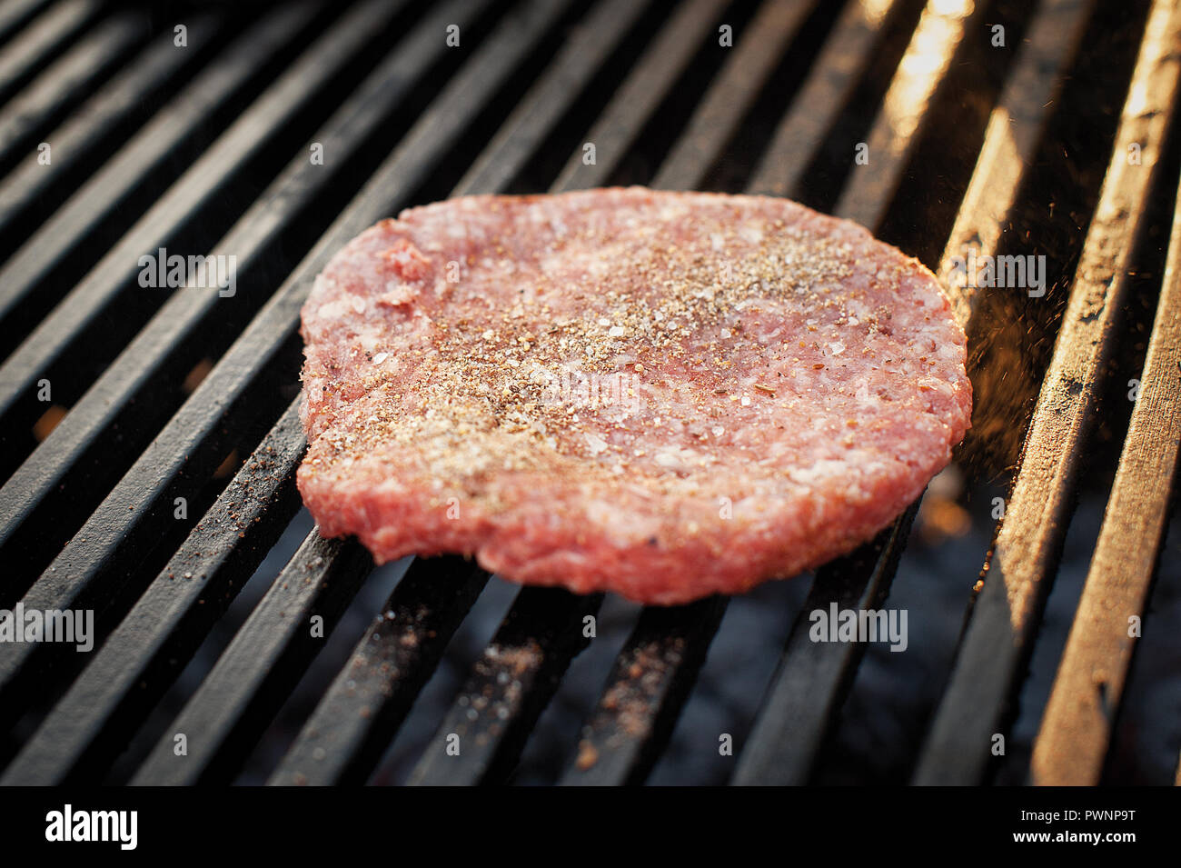 Preparing beef cutlet with spices for burgers on the grill. Street food