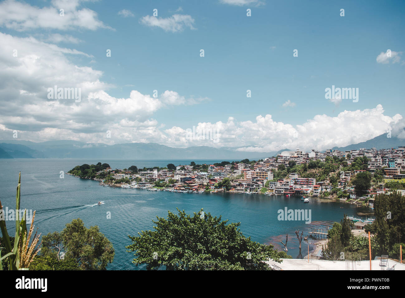 Water taxi boat pulls into the lakeside tourism town of San Pedro La Laguna, known as the party destination of Lake Atitlán, Guatemala Stock Photo