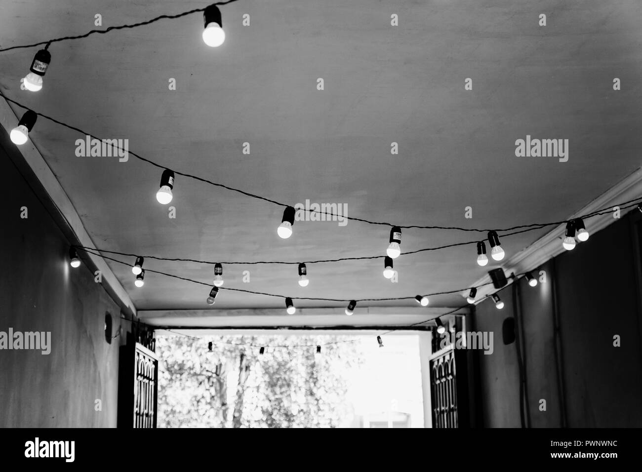 The ceiling in the street cafe is decorated with a garland with light