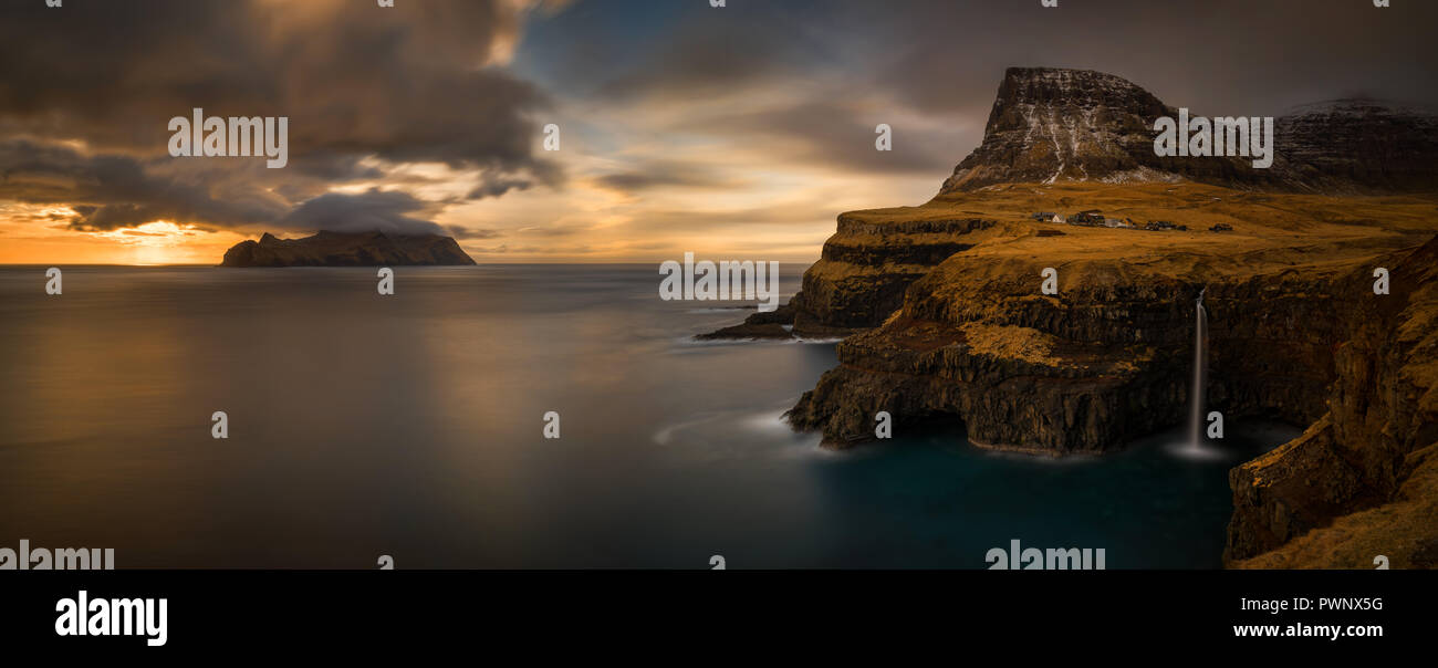 Autumn panorama of Gasadalur village and cloudy Mykines island in sunset, Faroe Islands Stock Photo