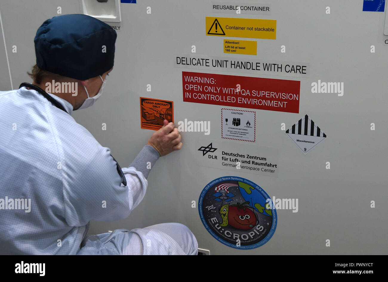 17 October 18 Bremen An Employee Of The German Aerospace Center Deutsches Zentrum Fur Luft Und Raumfahrt Dlr Sticks Signs On The Crate In Which The Research Satellite Eu Cropis Is Travelling The