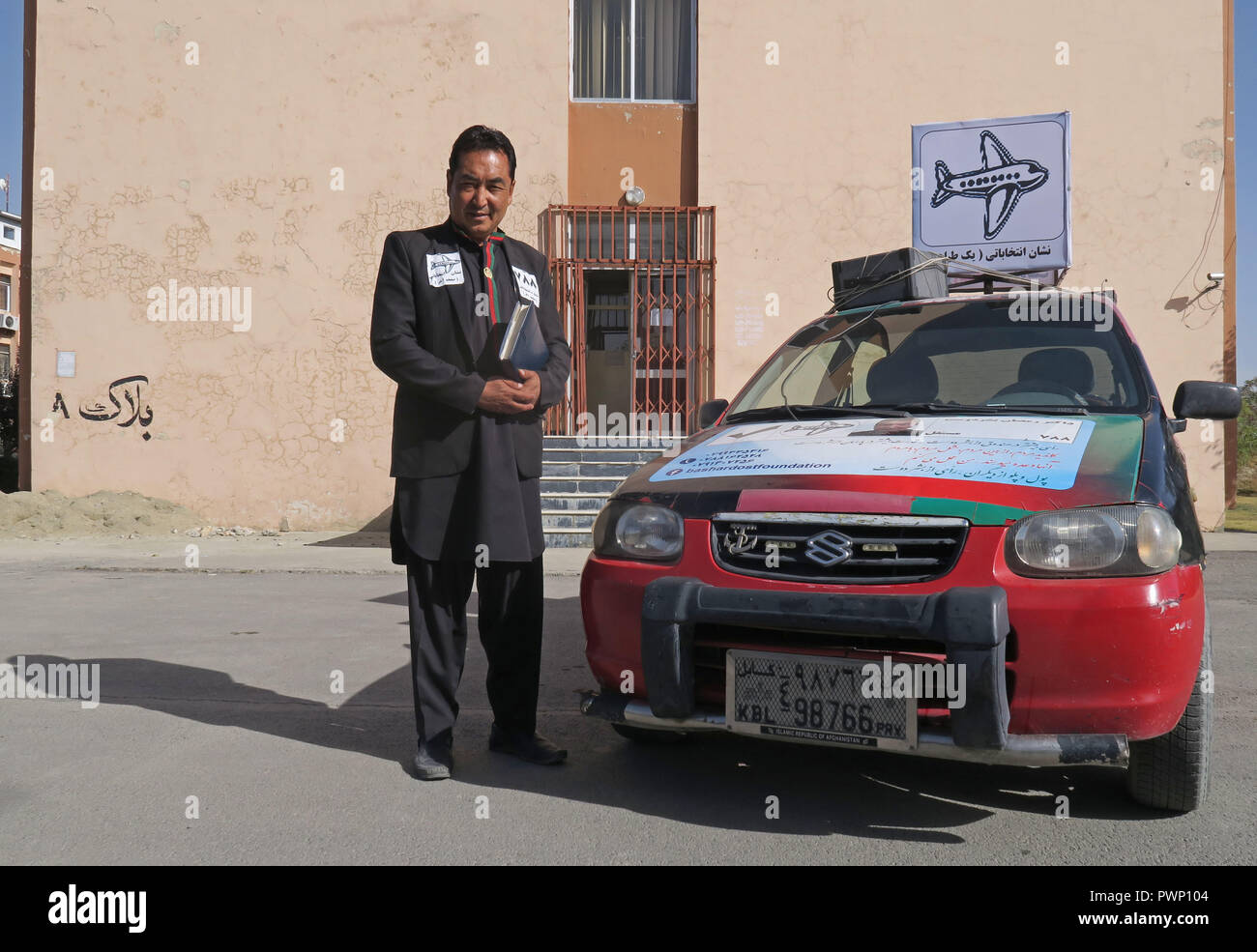 11 October 2018, Afghanistan, Kabul: Ramasan Baschardust, Afghan  parliamentarian and former planning minister, stands next to his car that  he has stuck on in the Afghan national colours. Bashardust has the  reputation