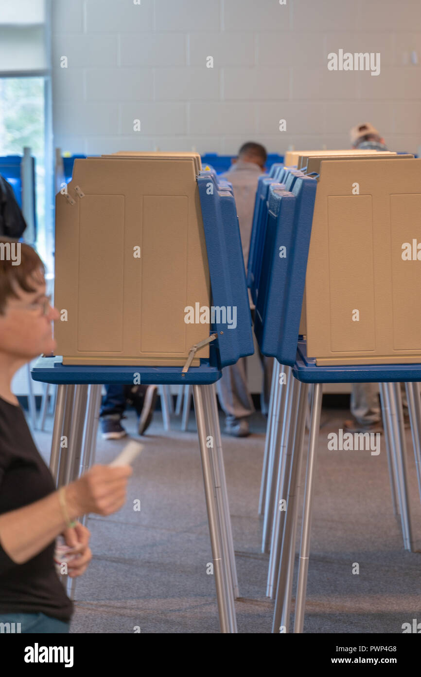 Raleigh, North Carolina, USA. 17th Oct, 2018.  Volunteer hands out "I voted early" stickers to voters as they leave the polling place. Credit: Michael Reilly/17�Թ����� Live News Stock Photo