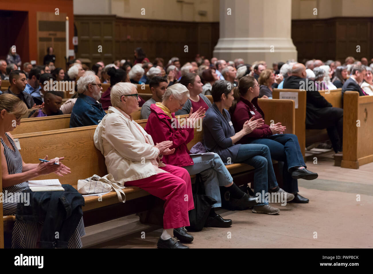 Seattle, Washington DC, USA. 17th Oct 2018. Supporters cheer for Attorney General Bob Ferguson during a discussion on the current state immigration. “Immigration Reform in Washington State” was hosted by St. Mark's Episcopal Cathedral and included a panel with representatives from Casa Latina, El Centro de la Raza and the Church Council of Greater Seattle. Credit: Paul Christian Gordon/Alamy Live News Stock Photo