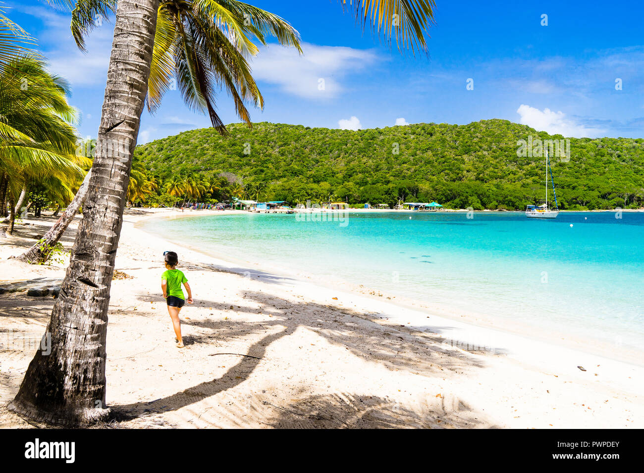 A boy 6 years old walking on the Salt Whistle Bay's beach, Mayreau, Saint-Vincent and the Grenadines, West Indies Stock Photo