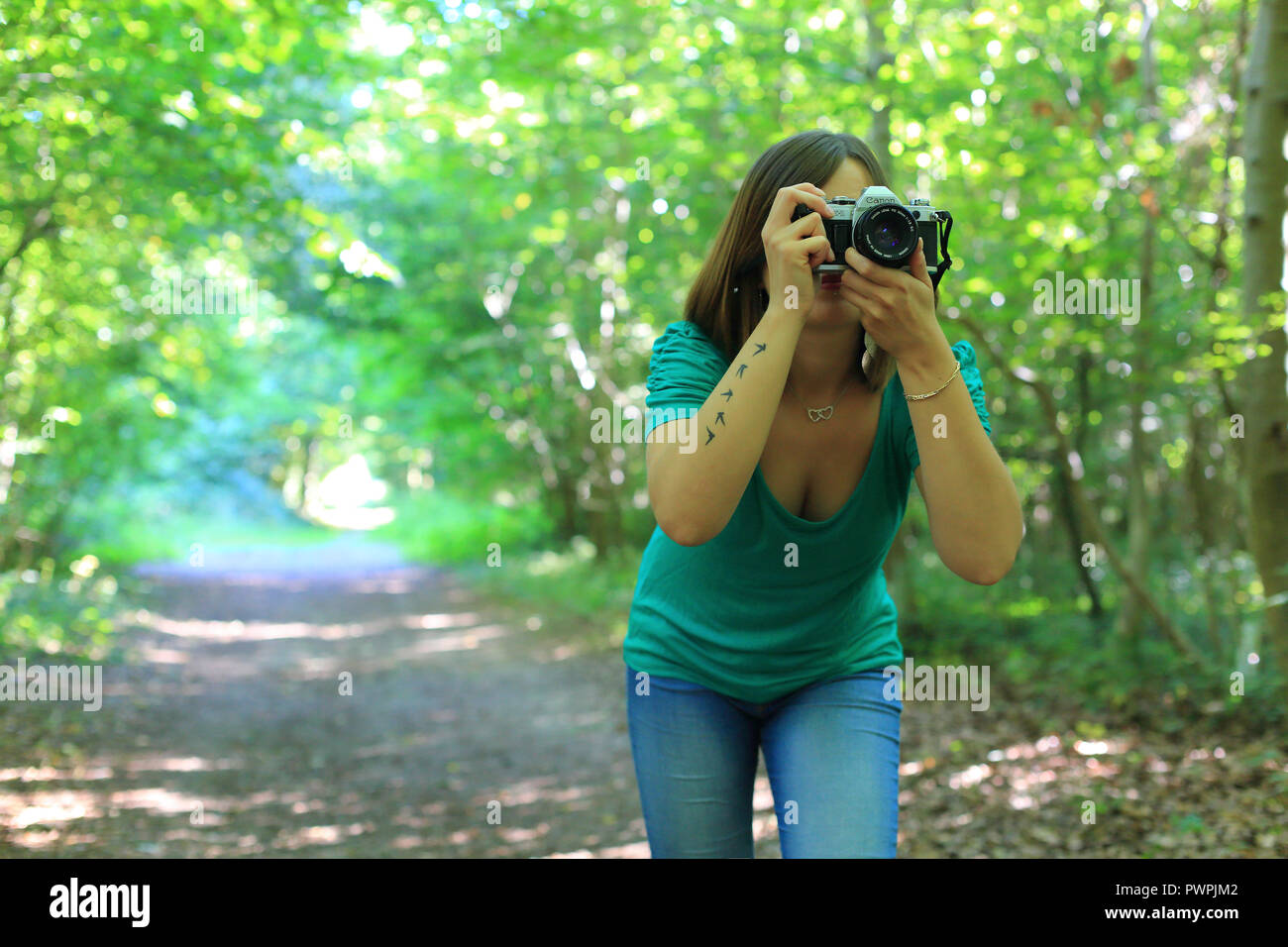 Young woman in forest with a camera Stock Photo - Alamy