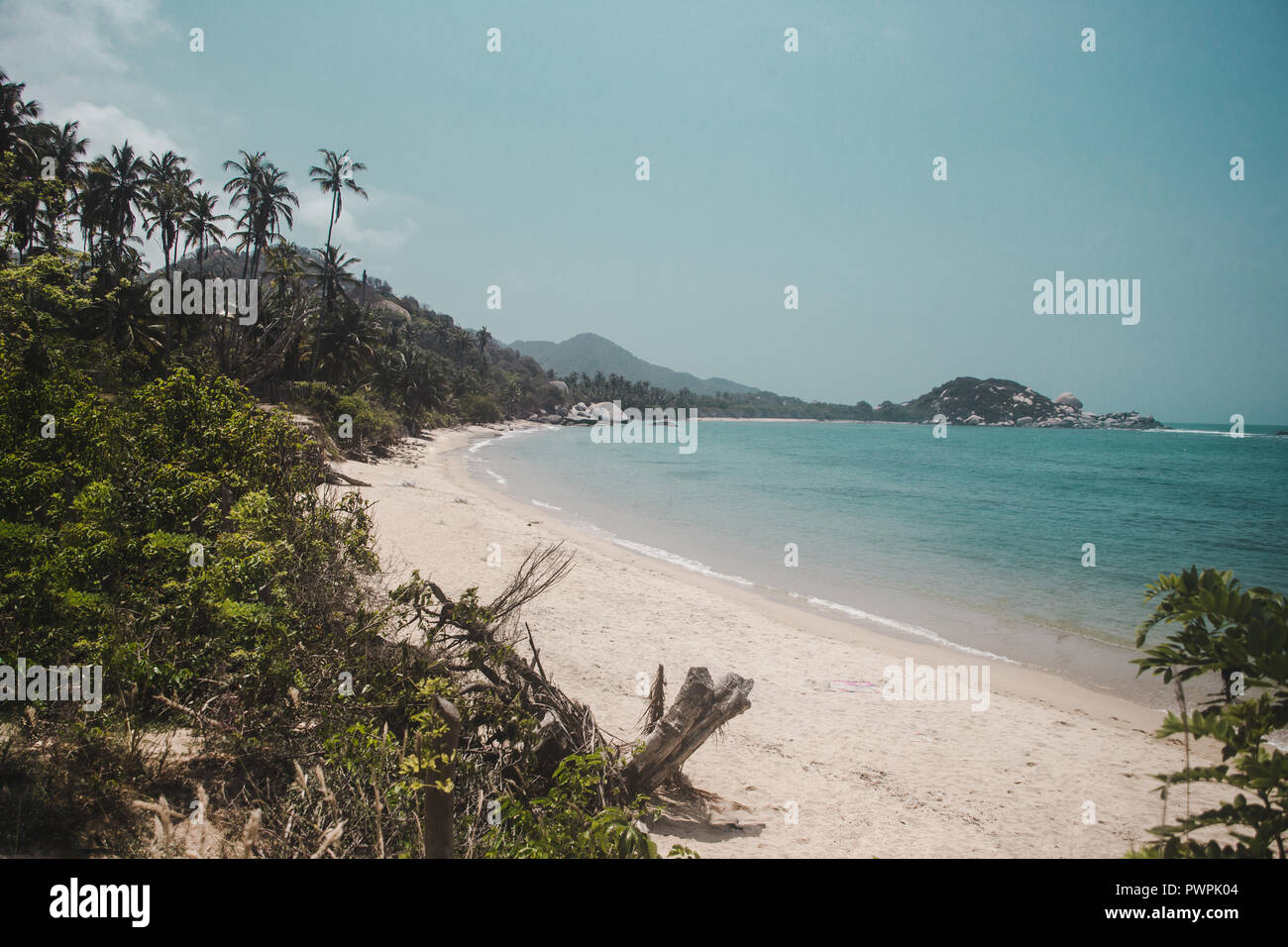 Pristine white sand beach of Tayrona National Park surrounded by jungle on the Caribbean coast of Colombia Stock Photo