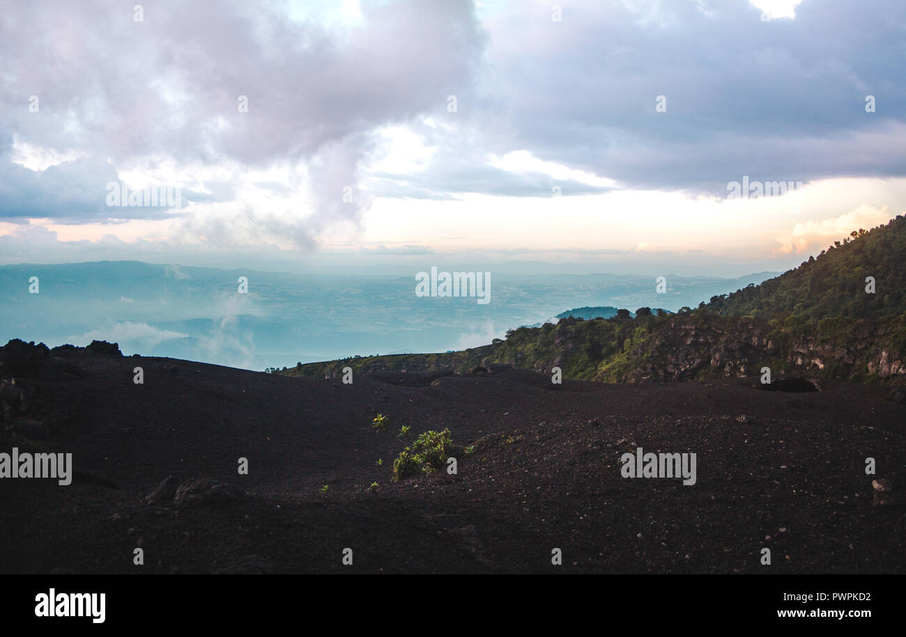 Changing landscapes around the Volcan Pacaya, one of Guatemala's most active volcanoes, from black volcanic rock to lush green forests at sunset Stock Photo