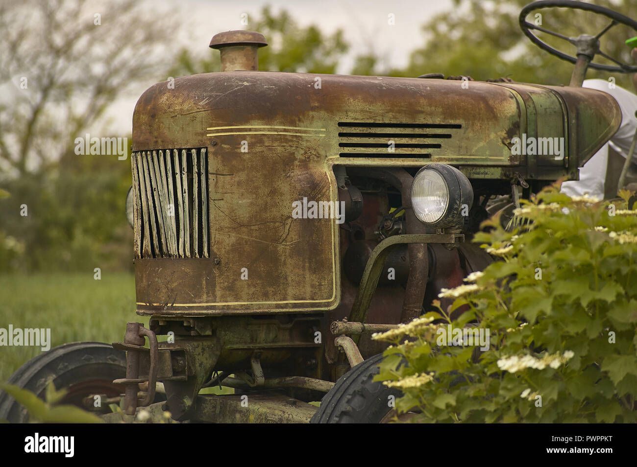 Vecchio trattore vintage usurato e con i segni del tempo in un campo pronto per un'altra dura giornata di lavoro Stock Photo