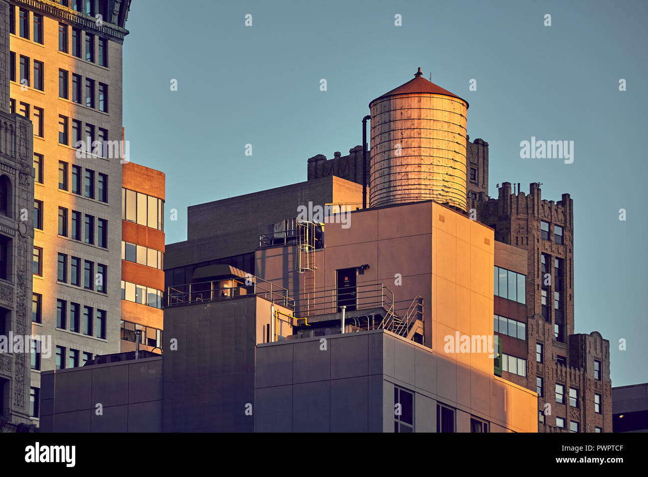 Vintage toned picture of water tank on rooftop at sunset, New York City
