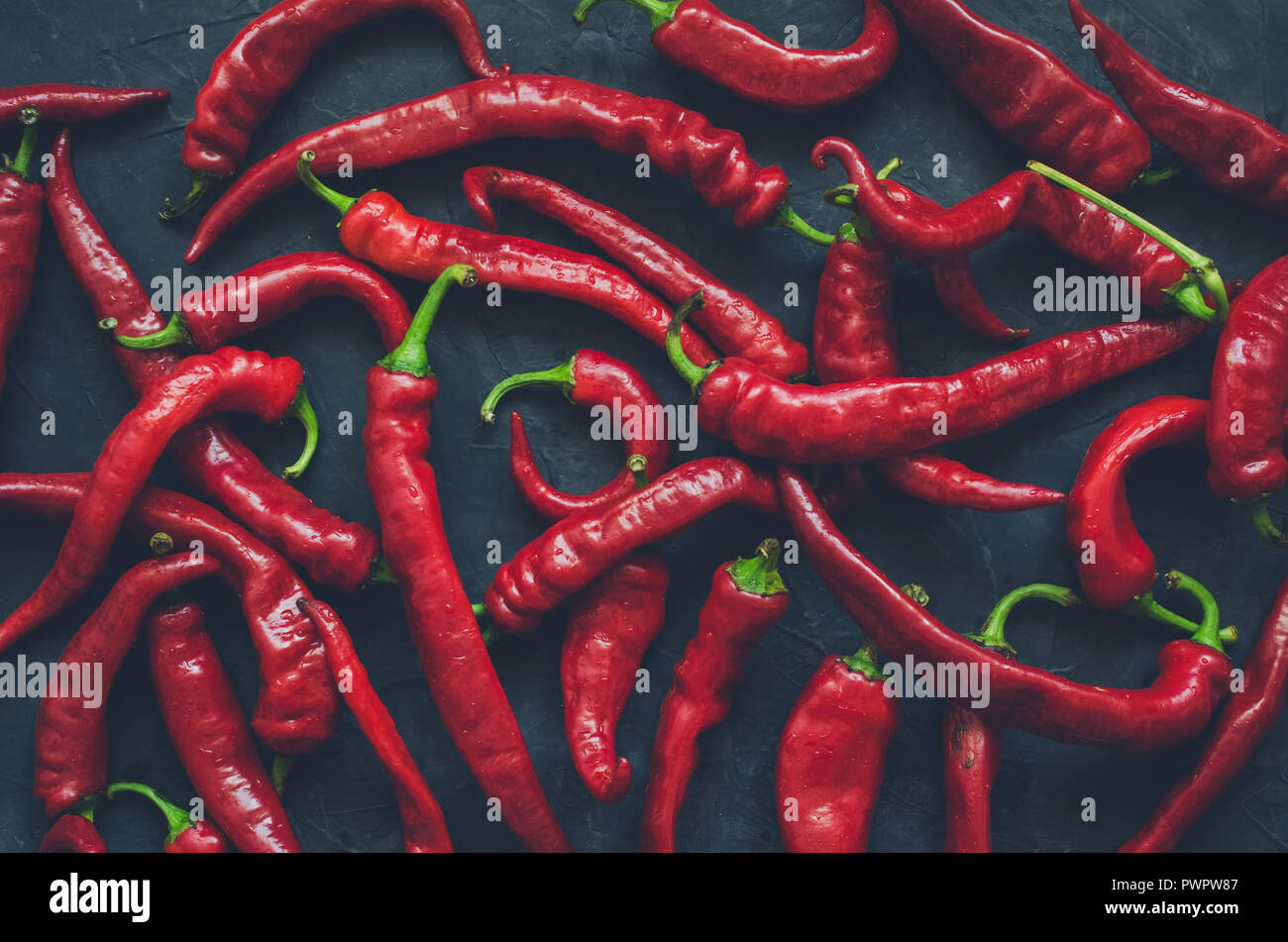 Red hot chili peppers over dark background. Dark food photography wallpaper  texture. Top view Stock Photo - Alamy