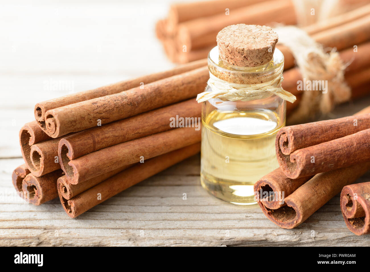 cinnamon oil and cinnamon sticks on the wooden board Stock Photo
