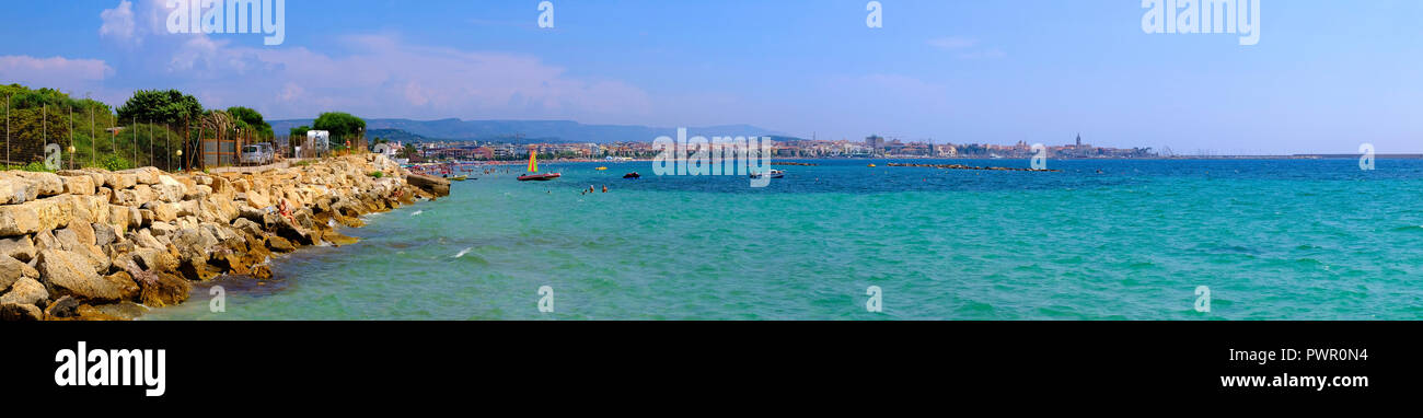 Alghero, Sardinia / Italy - 2018/08/08: Panoramic view of the Gulf of Alghero with historic quarter and Alghero old town in background Stock Photo