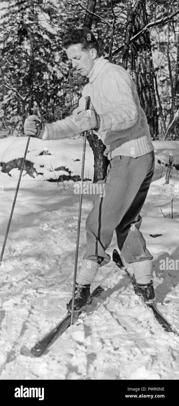 Winter in the 1960s. A man is turning on his skies and has one leg and foot in one direction, and the other one in a different direction. The manor of doing it is a visual describtion and a suitable symbolic image to illustrate something that changes in a surprising way. Sweden 1960 Ref BV58-3 Stock Photo