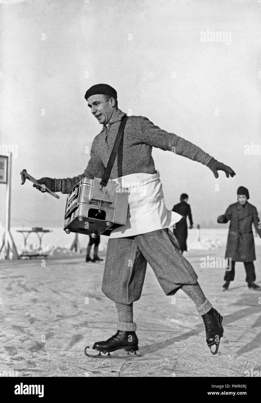 skating-hot-dog-salesman-a-man-selling-sausages-is-skating-on-the-ice-a-winter-day-the-box-hanging-in-front-of-him-contains-the-hot-dogs-1930s-PWR0RJ.jpg