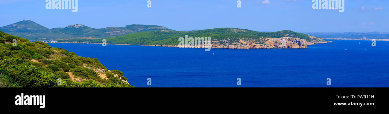 Alghero, Sardinia / Italy - 2018/08/11: Panoramic view of the Gulf of Alghero with cliffs of Punta del Giglio and city of Alghero in background Stock Photo
