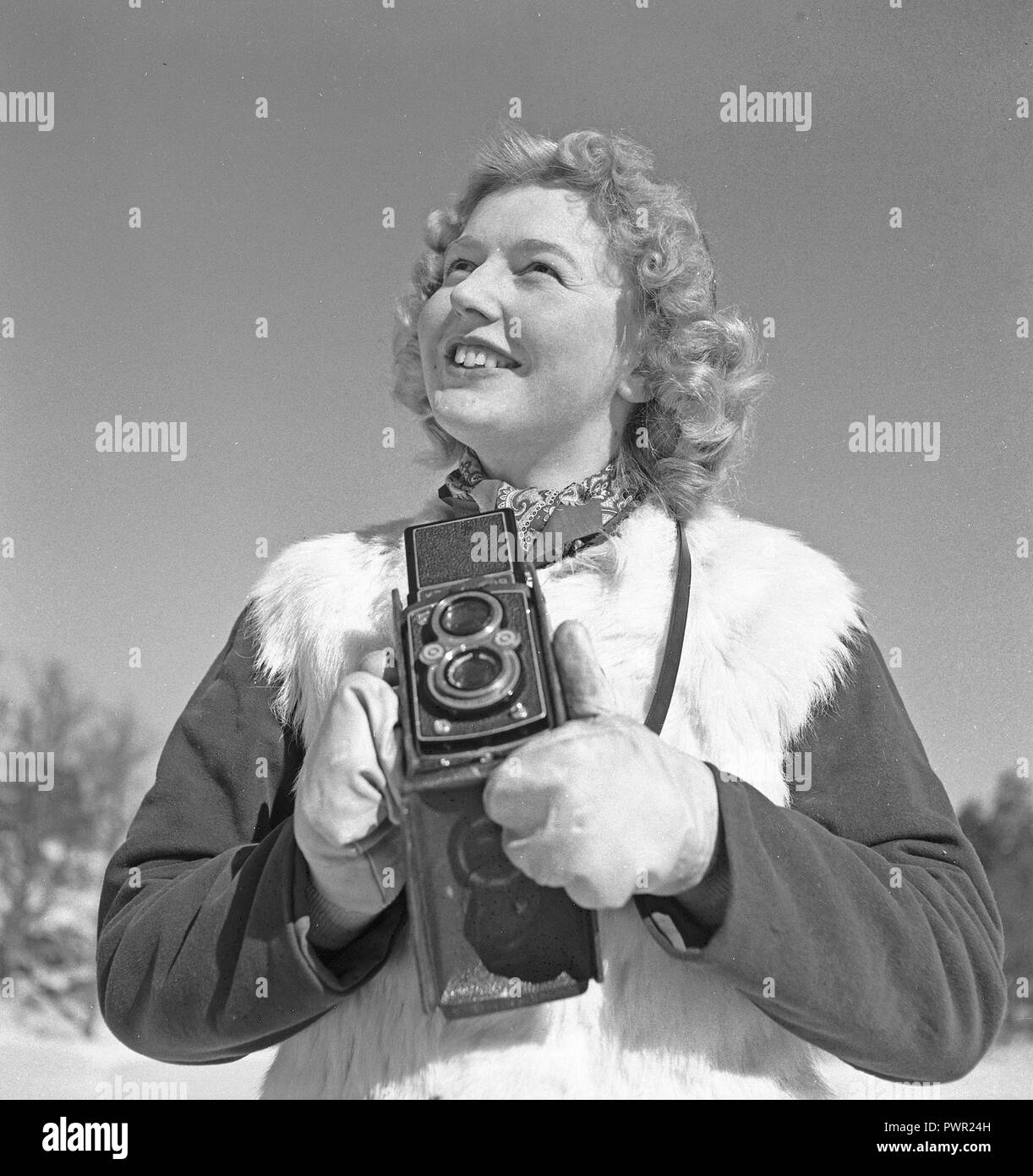 Winter in the 1940s. A young woman is photographing on a winter day. The camera is a Rolleiflex by the german company Rolle for 60 mm film.  Sweden 1944. Photo Kristoffersson Ref F31-6 Stock Photo