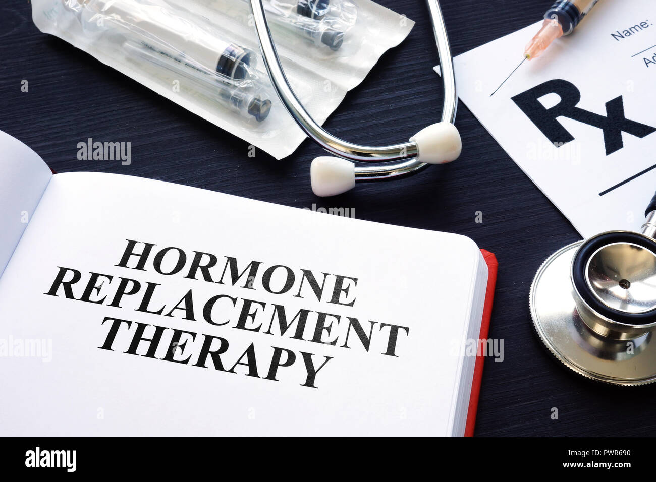 Book about Hormone Replacement Therapy and syringes. Stock Photo