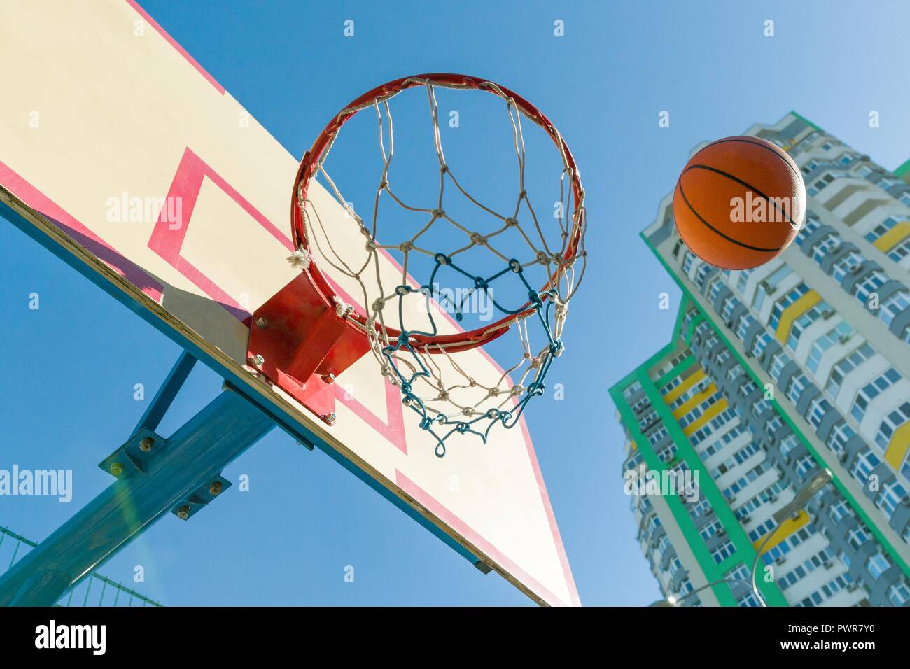 Street basketball, close-up of basketball ring and ball flying into the basket Stock Photo