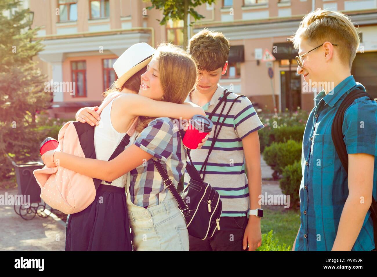 Group of happy teenagers 13, 14 years walking along the city street, friends greet each other at a meeting. Friendship and people concept Stock Photo