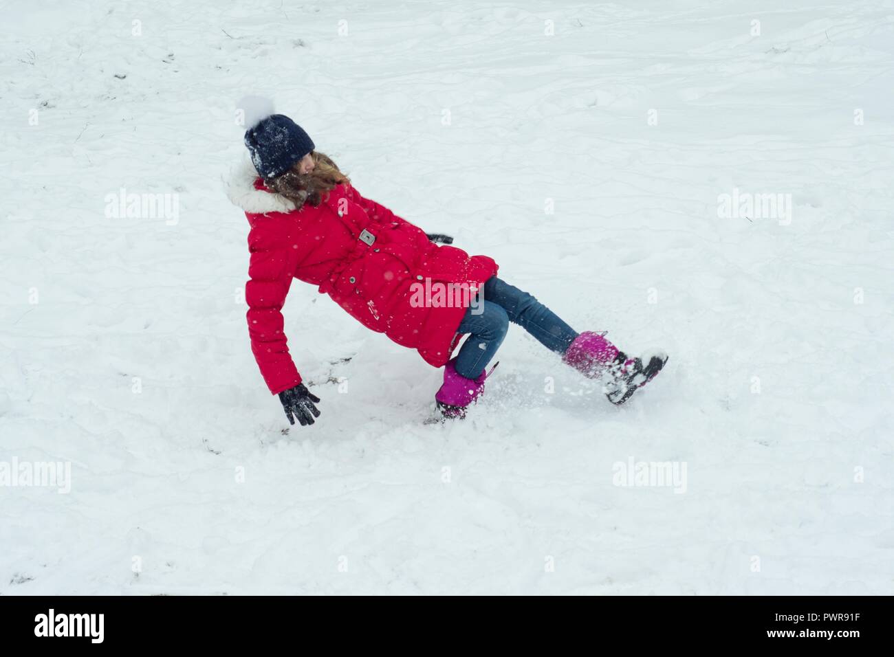 Winter danger, the girl slipped and falls. Stock Photo