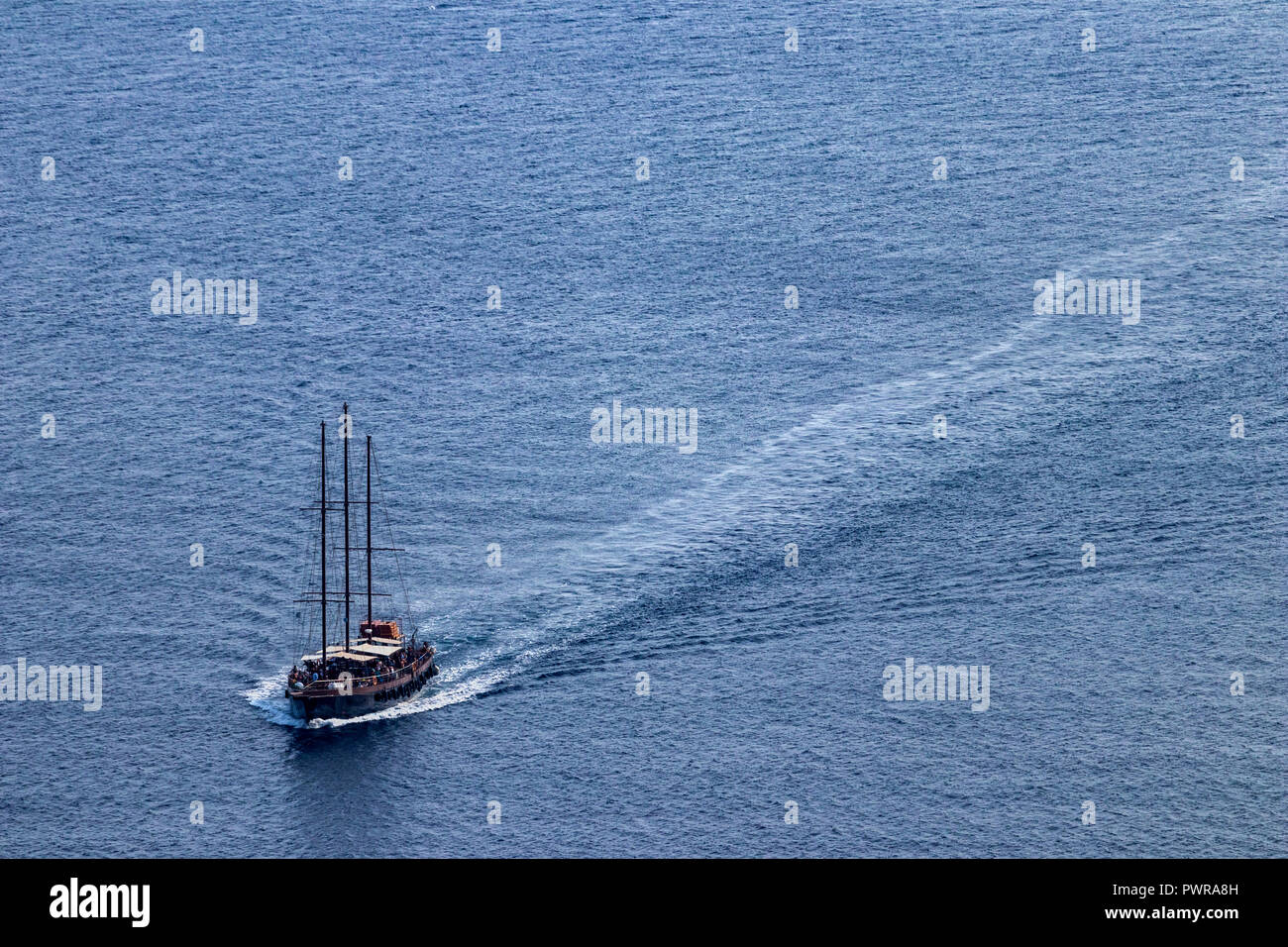 Luxury vintage two masted tourist boat sails the Aegean sea, near Santorini island, Greece, August 2018, aerial view. Stock Photo