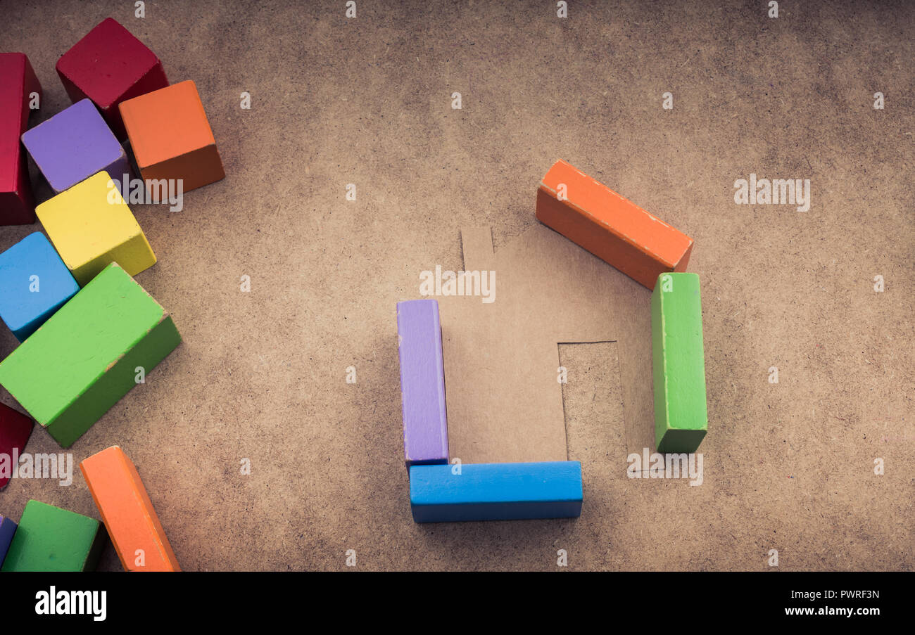 House shape formed out of building blocks on a brown background Stock ...