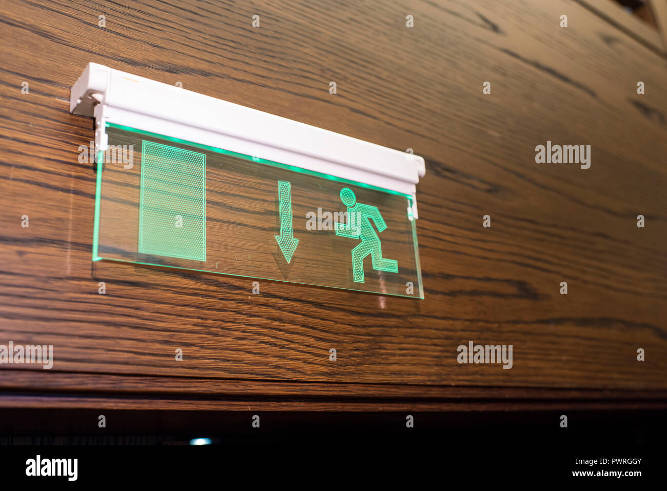 glowing exit sign on the wall Stock Photo