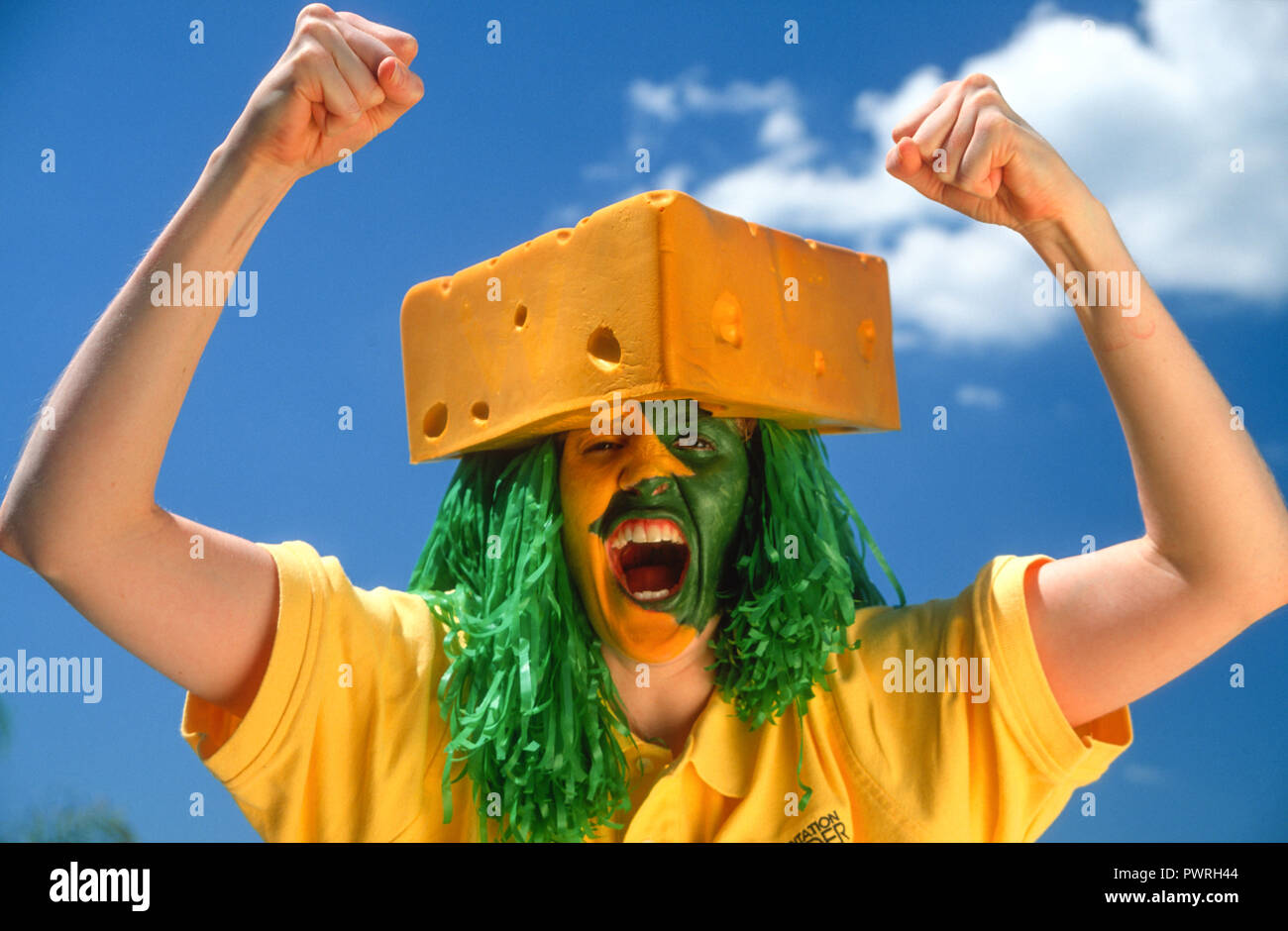 Enthusiastic Cheesehead Sports Fan with Painted Face at a Football Game