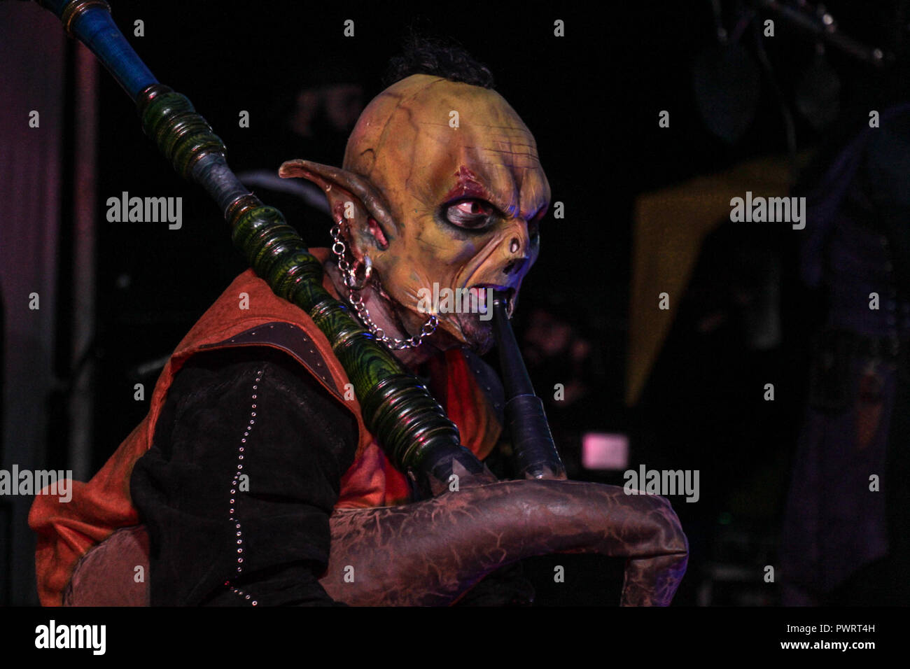 scary orc green playing the bagpipes at night in medieval ritual Stock Photo