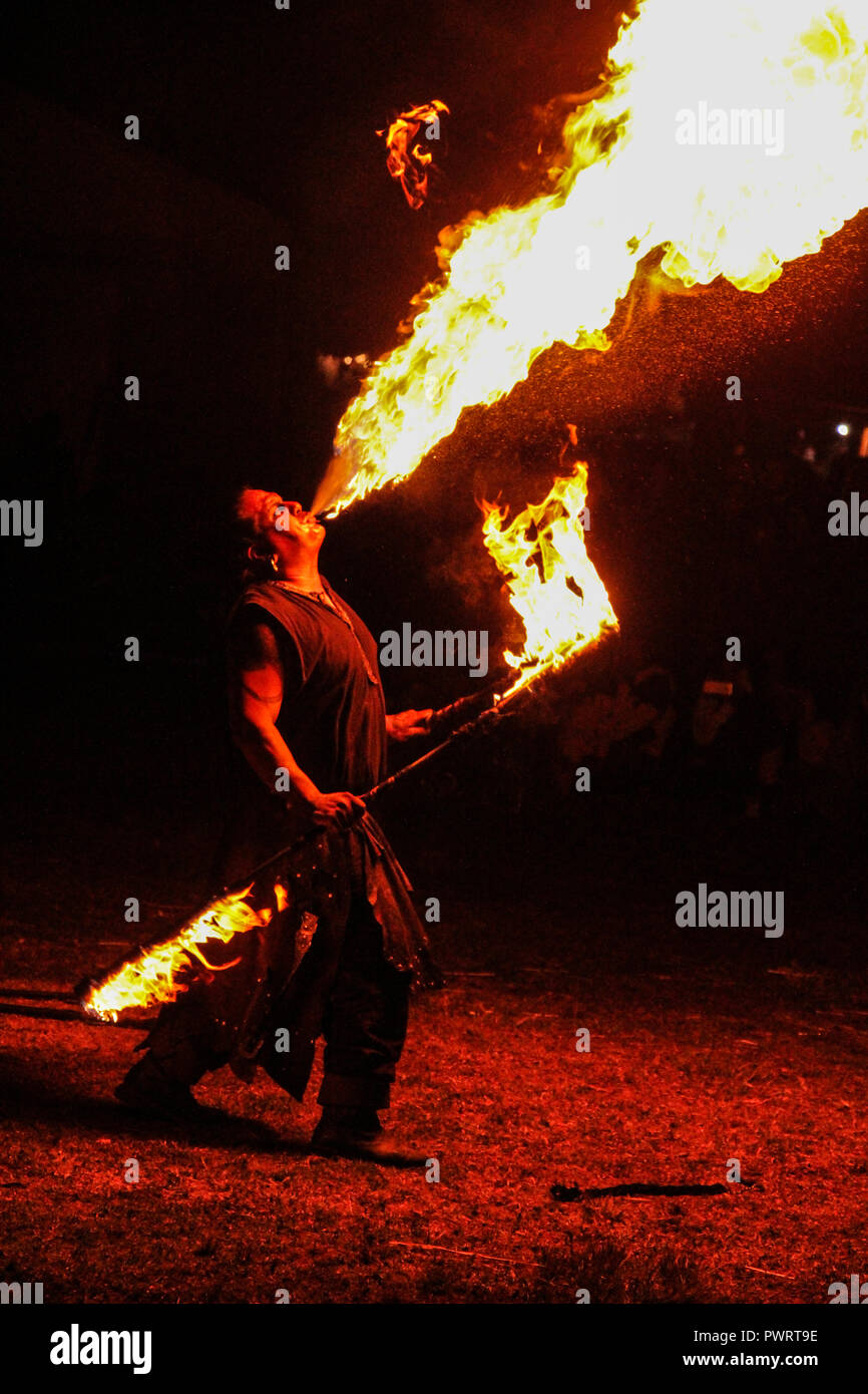 fire-eater in night show at medieval festival with black background Stock Photo