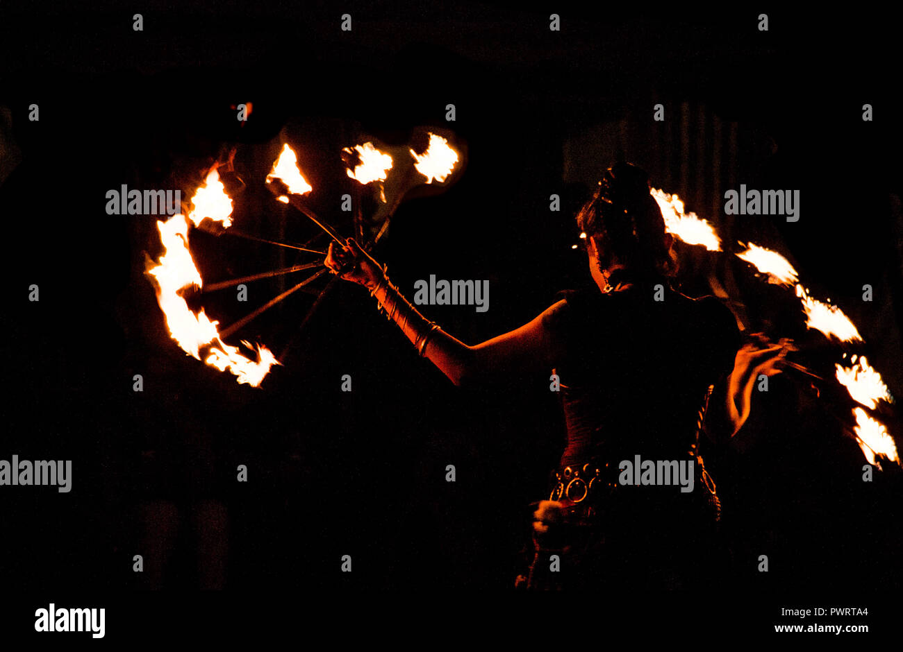fireeater, fire dancer with flaming hoop in night show at medieval