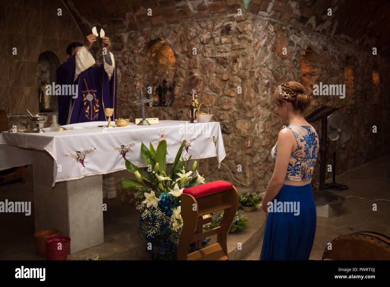 girl in blue lace dress receiving the gospel in stone church Stock Photo