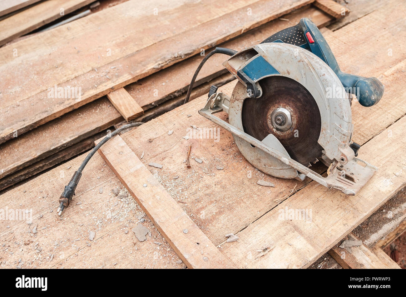 Circular saw over a pile of wooden planks. Tool used to saw wood