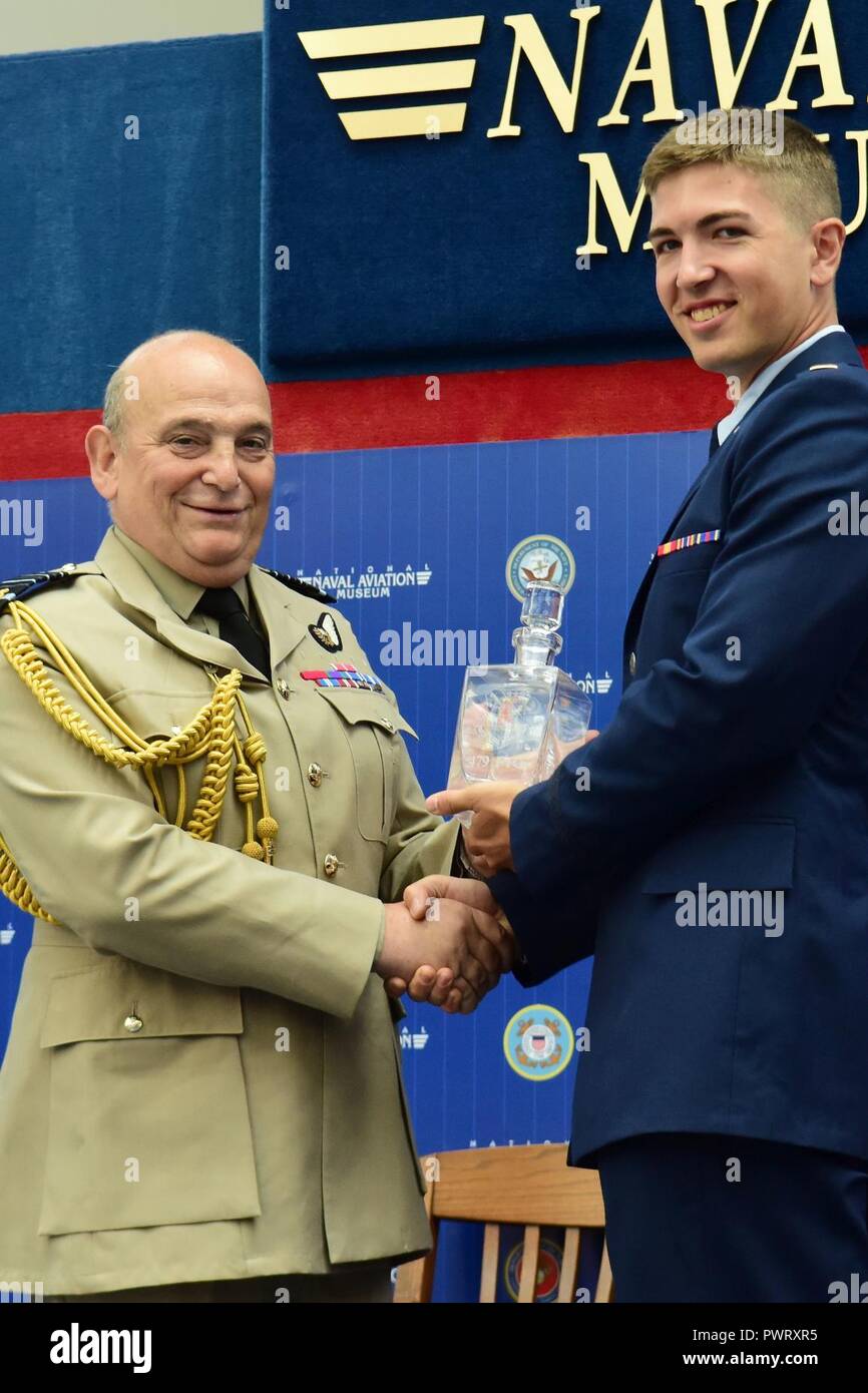 Air Chief Marshal Stuart Peach, Chief of the Defence Staff of the United Kingdom is presented with a gift by the combat systems officer class 17-11 class leader 2nd Lt. David Breeze during the graduation ceremony held inside the Naval Aviation Museum, Naval Air Station Pensacola, Florida., June 23, 2017. Stock Photo