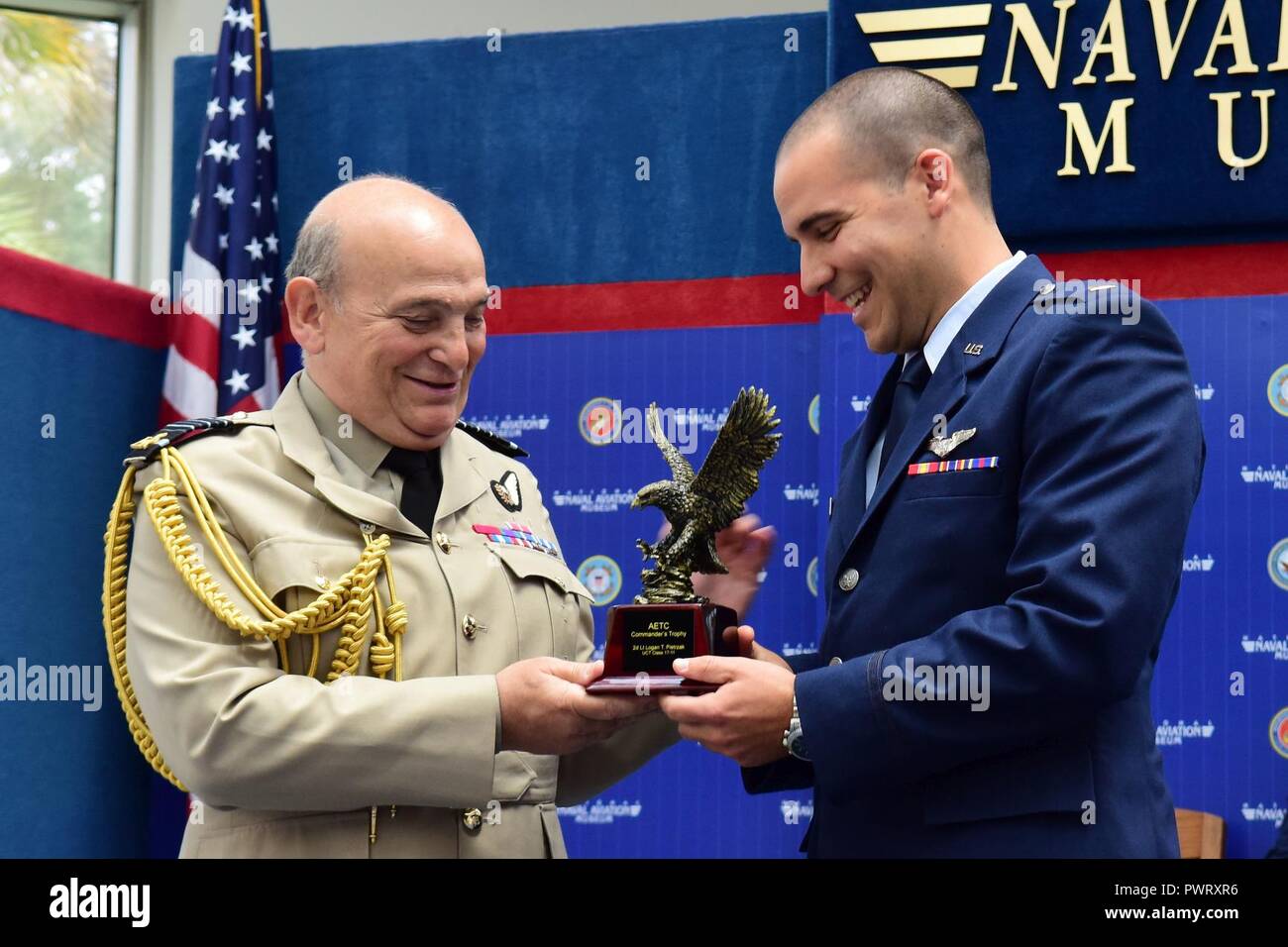 Air Chief Marshal Stuart Peach, Chief of the Defence Staff of the United Kingdom presents the Air Education Training Command Commander’s Trophy for Combat Systems Officer Class 17-11 to 2nd Lt. Logan Pietrzak during the graduation ceremony held inside the Naval Aviation Museum, Naval Air Station Pensacola, Florida., June 23, 2017. Stock Photo