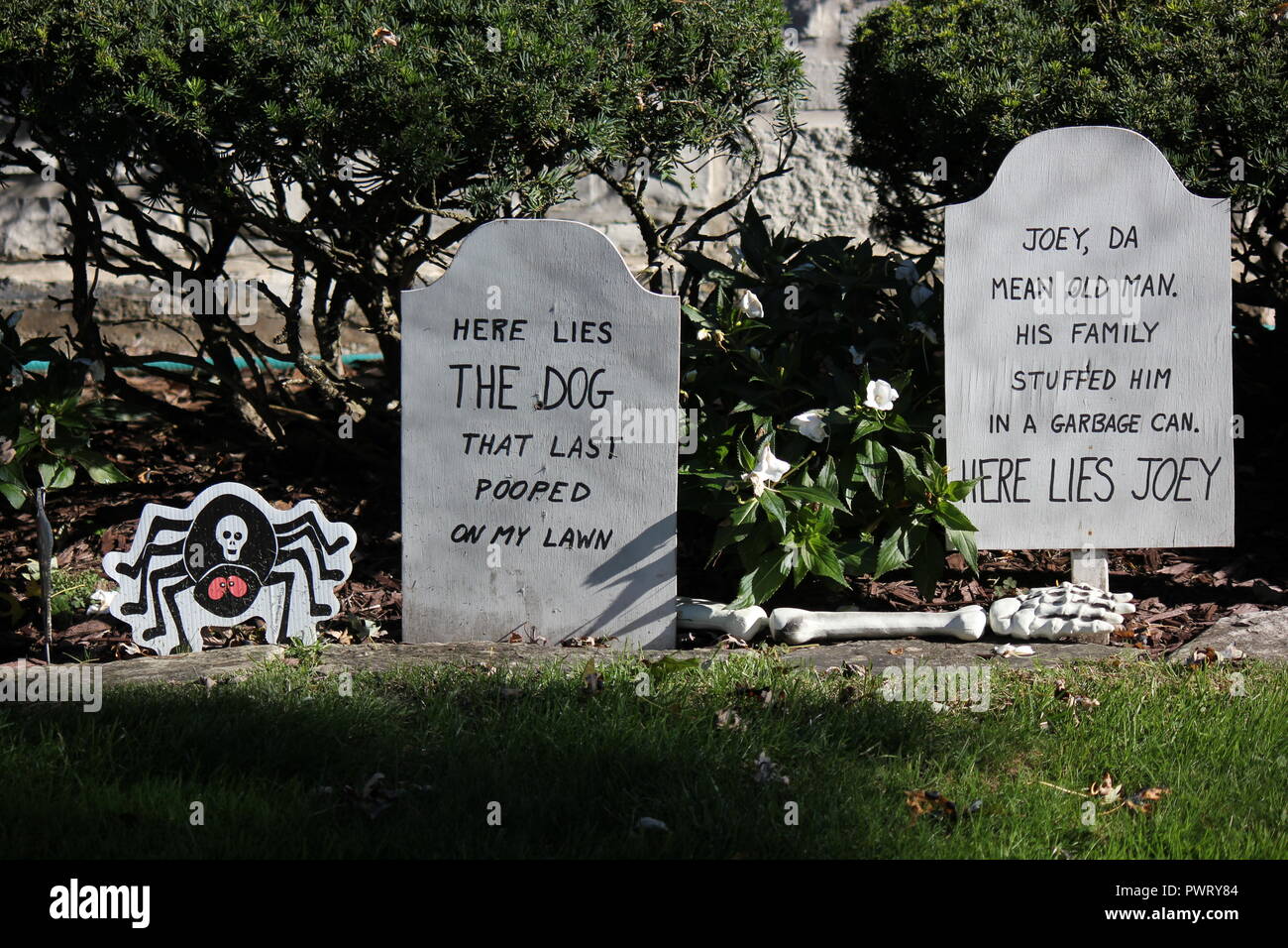 Two Handmade handwritten tombstones posing as Halloween lawn decorations with a scary epitaph. Stock Photo